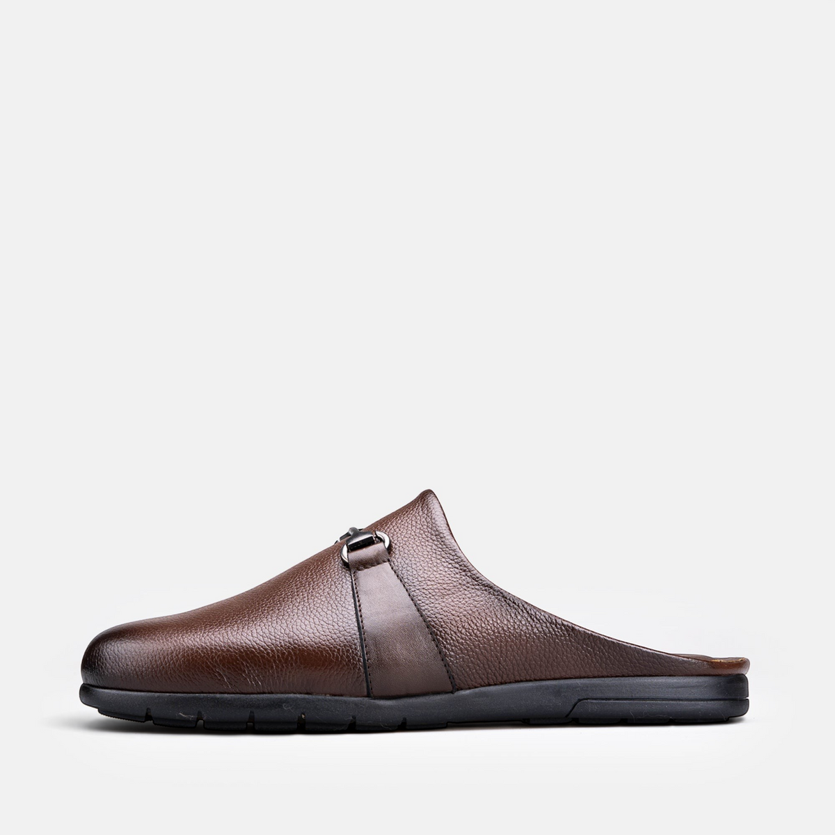 VOLZAK brown grained leather mule with a metal buckle detail and a durable black rubber sole, side view.