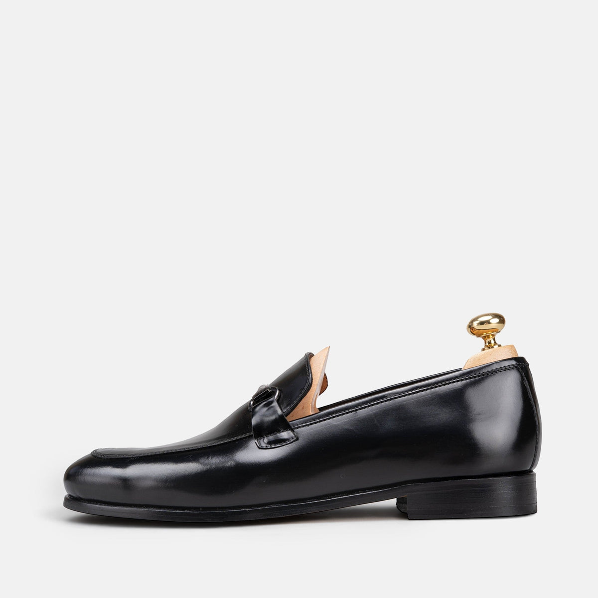 VOLZAK black leather loafer with a sleek silhouette and metal buckle detail, side view